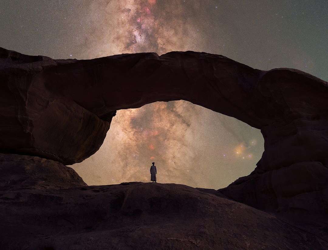 Wadi Rum desert landscape with red sand dunes and sandstone mountains at sunset